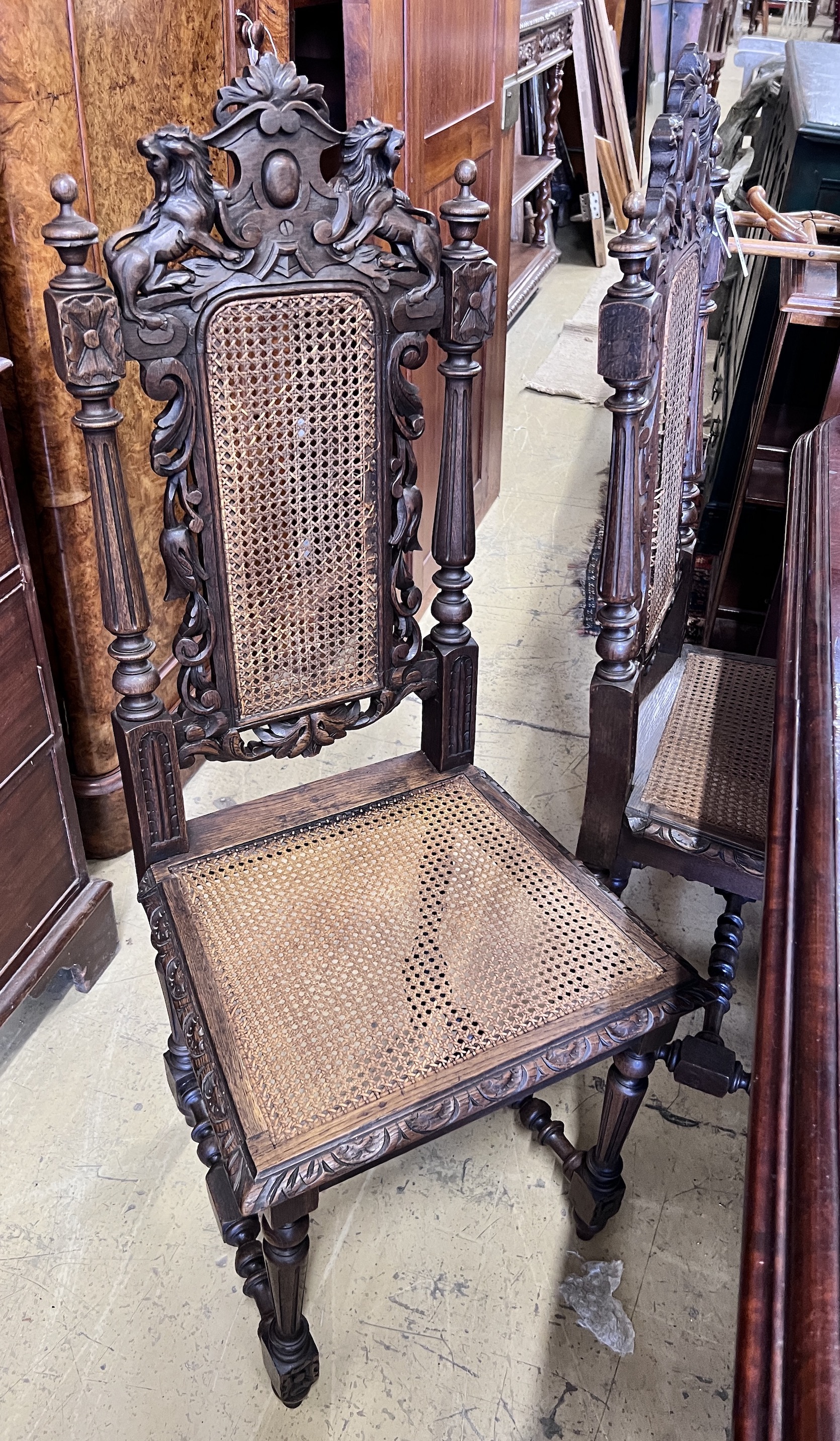 A set of four late 19th century Flemish style carved oak dining chairs with caned seats